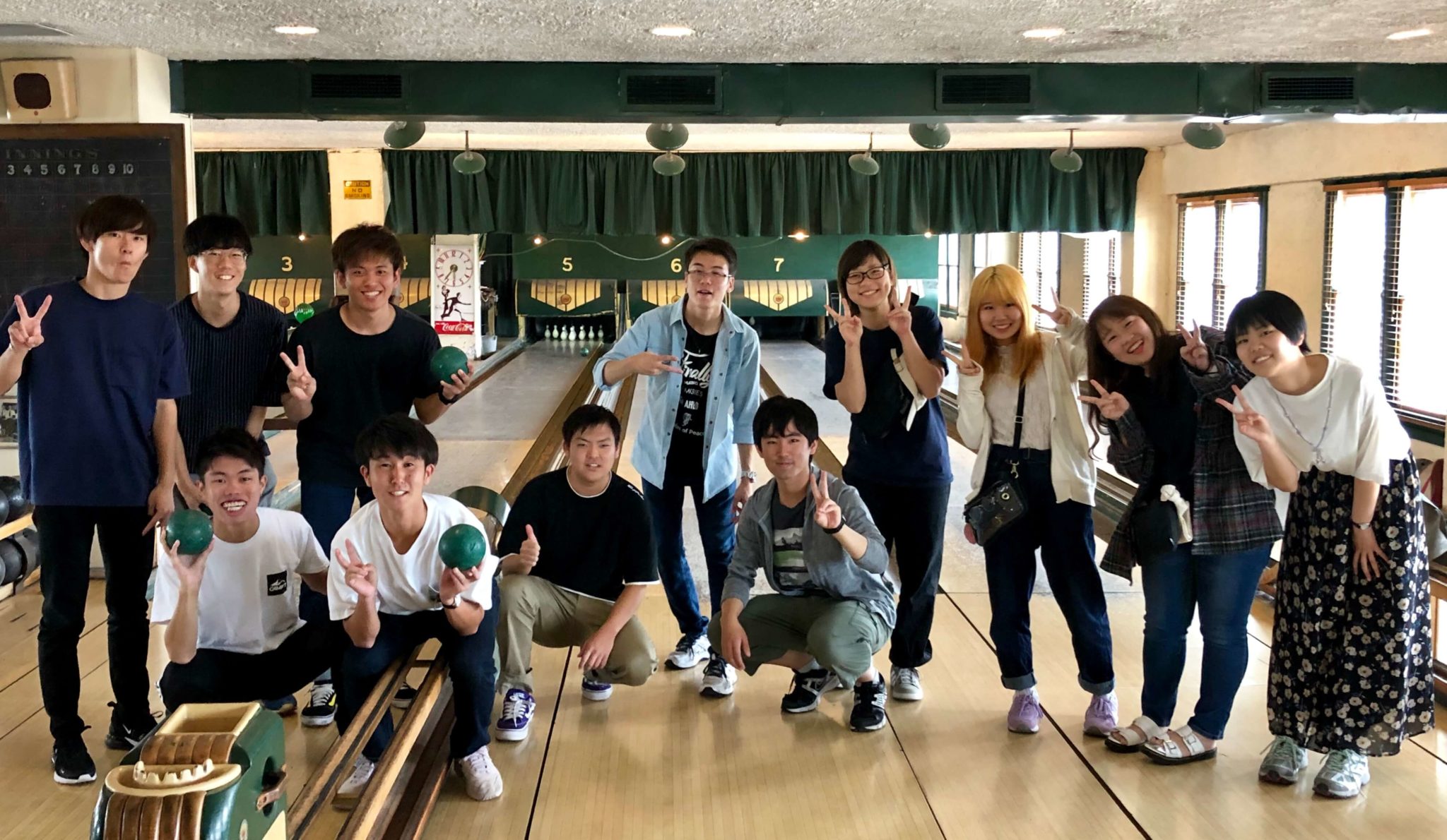 Group of students posing in front of a mini bowling alley.